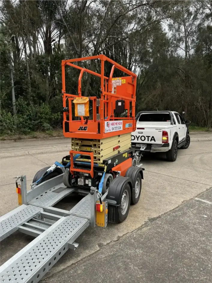 scissor lift trailer being towed by a car